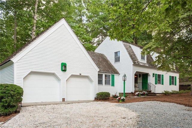 view of front of home featuring a garage and gravel driveway