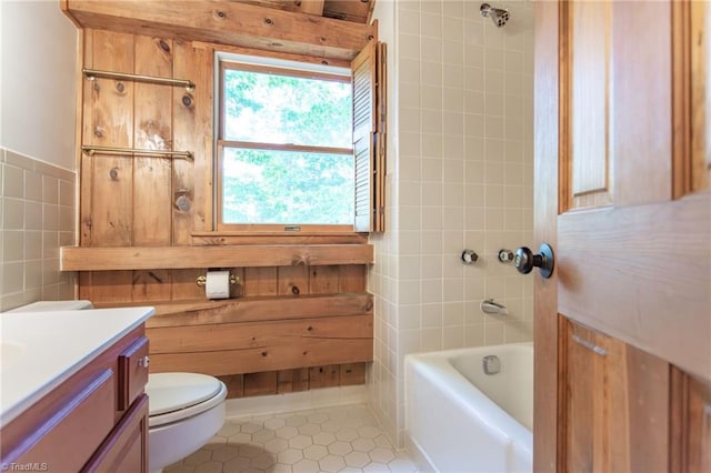 bathroom featuring toilet, tile patterned flooring, tile walls, and vanity