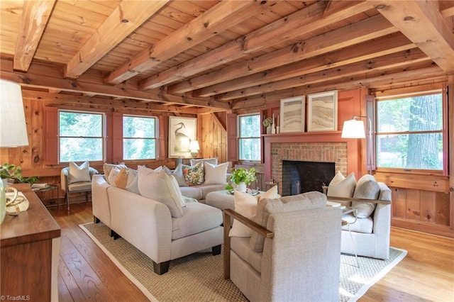 living area with beamed ceiling, light wood-type flooring, and wooden walls