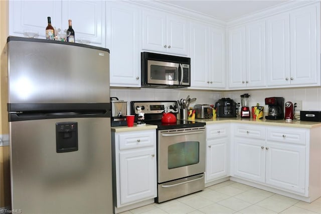 kitchen featuring backsplash, white cabinetry, light tile patterned flooring, ornamental molding, and stainless steel appliances