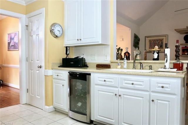 kitchen featuring white cabinets, sink, beverage cooler, and light tile patterned flooring