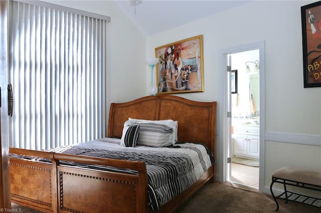 carpeted bedroom featuring connected bathroom and vaulted ceiling