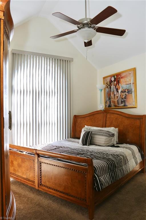 bedroom featuring lofted ceiling, dark carpet, multiple windows, and ceiling fan