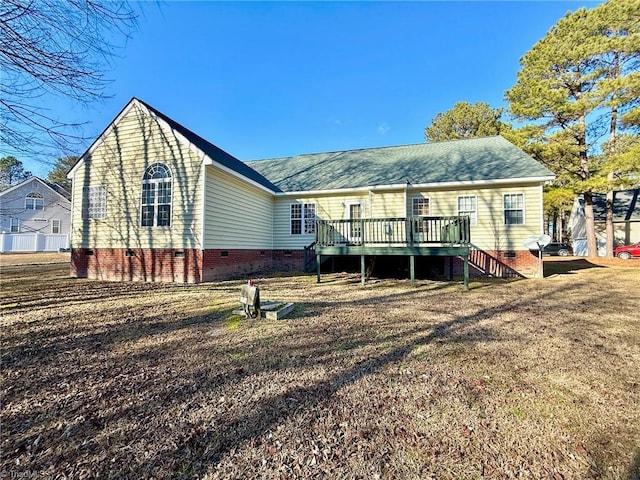 rear view of property with a deck and a lawn