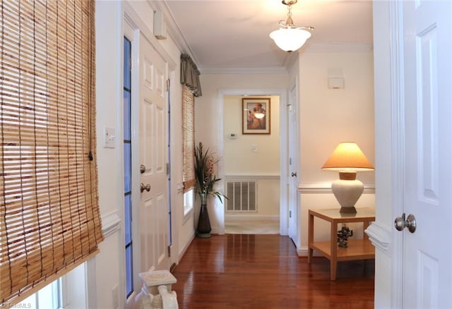 hall featuring ornamental molding and dark hardwood / wood-style flooring