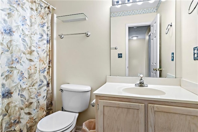 bathroom with walk in shower, vanity, and toilet