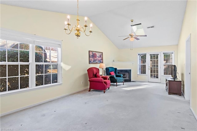 living area featuring ceiling fan with notable chandelier, high vaulted ceiling, and carpet