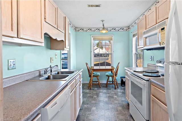 kitchen with white appliances, sink, hanging light fixtures, and light brown cabinets