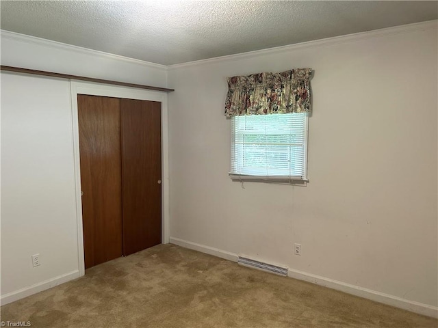 437 Charles Dr, Winston-Salem, NC 27107 - unfurnished bedroom featuring ornamental molding, a closet, carpet, a textured ceiling, and baseboards