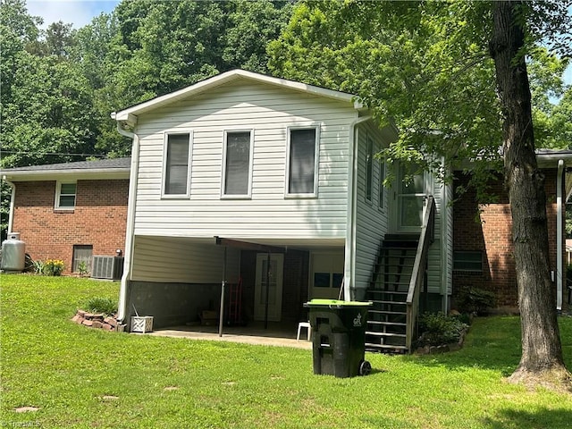 437 Charles Dr, Winston-Salem, NC 27107 - rear view of house with stairs, cooling unit, a yard, brick siding, and a patio