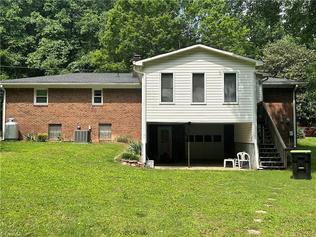 437 Charles Dr, Winston-Salem, NC 27107 - back of house with central AC, a garage, a yard, and brick siding