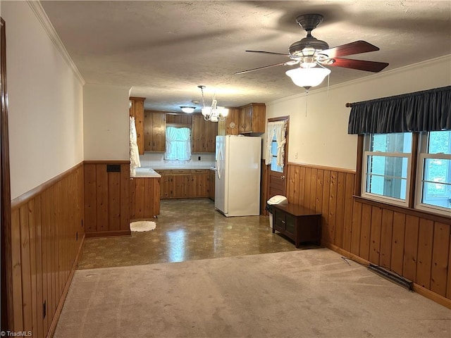 437 Charles Dr, Winston-Salem, NC 27107 - kitchen with freestanding refrigerator, wainscoting, brown cabinets, healthy amount of natural light, and wooden walls
