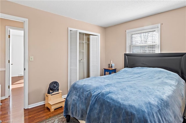 bedroom featuring a textured ceiling, dark hardwood / wood-style flooring, and a closet