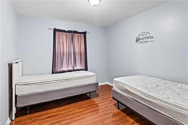 bedroom featuring hardwood / wood-style flooring and a textured ceiling