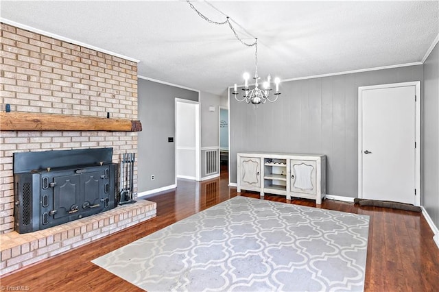 unfurnished living room with crown molding, a brick fireplace, dark hardwood / wood-style floors, and an inviting chandelier