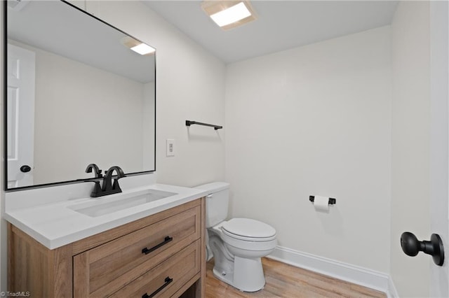 bathroom featuring toilet, vanity, and hardwood / wood-style flooring