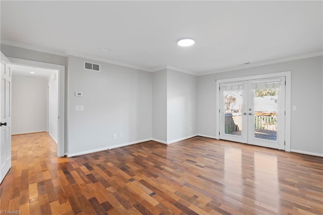 spare room featuring french doors, hardwood / wood-style flooring, and crown molding