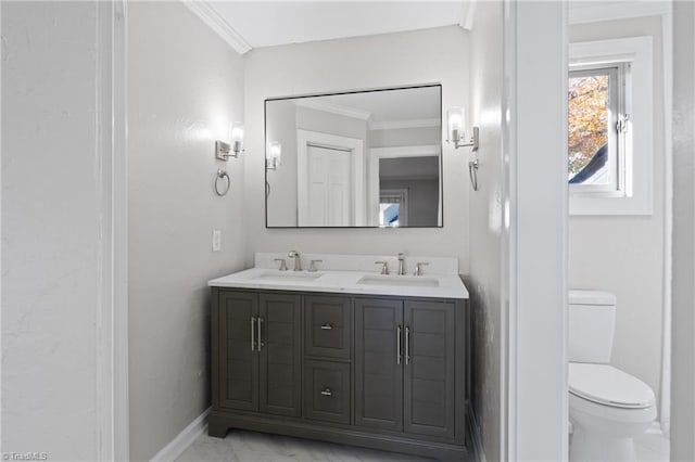 bathroom featuring toilet, vanity, and ornamental molding