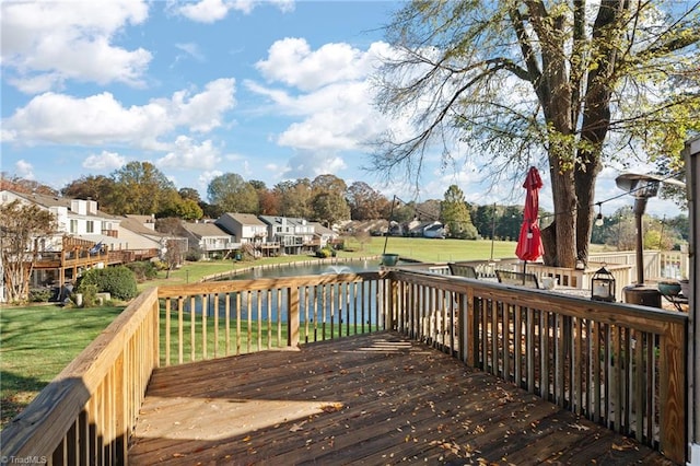 wooden deck featuring a water view and a yard