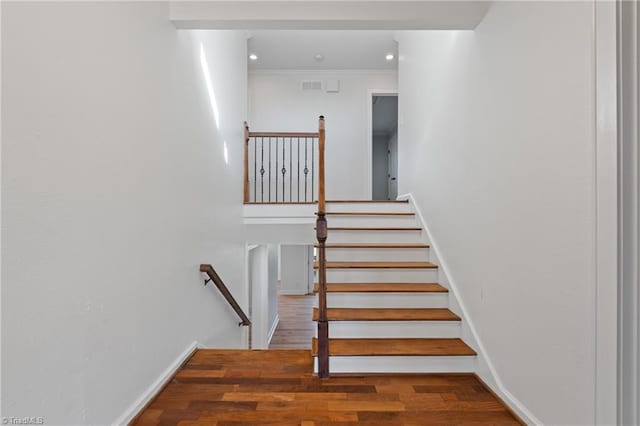 staircase featuring crown molding and wood-type flooring