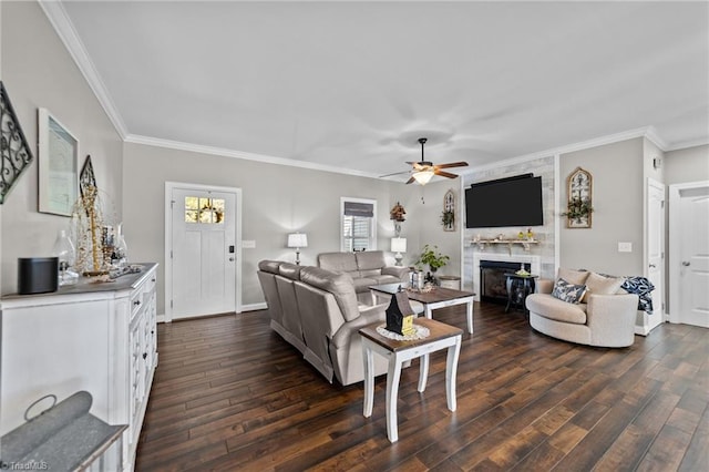 living room featuring ceiling fan, crown molding, a fireplace, and dark hardwood / wood-style flooring