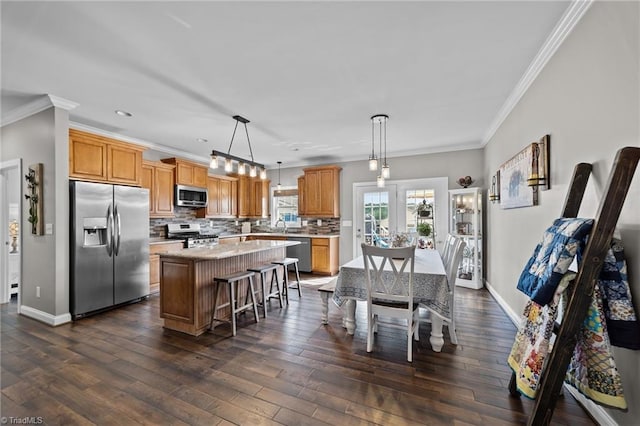 dining area featuring ornamental molding, dark hardwood / wood-style floors, and sink