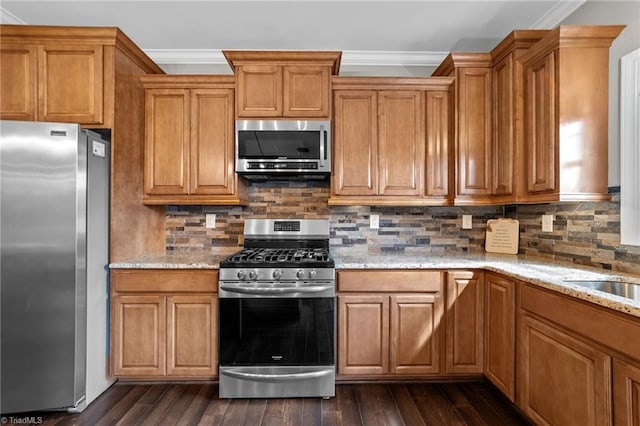 kitchen with light stone counters, appliances with stainless steel finishes, backsplash, and dark wood-type flooring