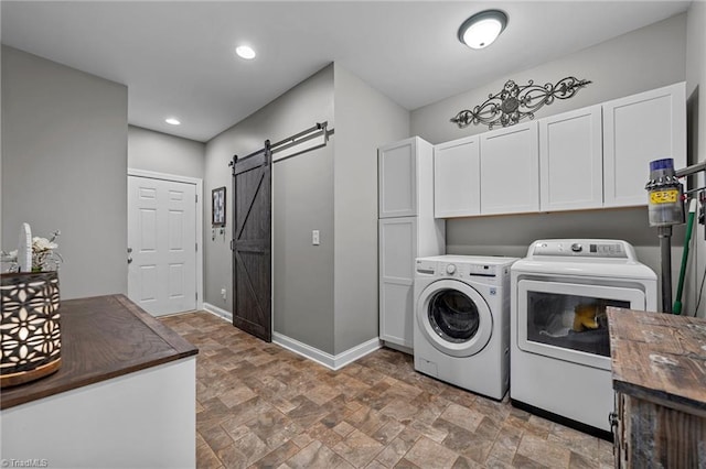 laundry area featuring cabinets, a barn door, and independent washer and dryer