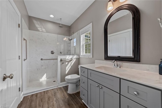 bathroom featuring walk in shower, wood-type flooring, vanity, and toilet