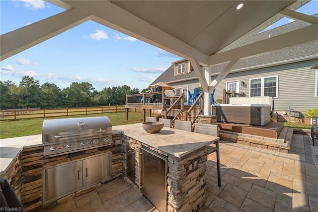 view of patio featuring area for grilling, an outdoor kitchen, and a wooden deck