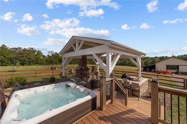 deck with a hot tub, a gazebo, and a rural view