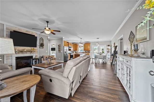 living room featuring ceiling fan, ornamental molding, and dark wood-type flooring