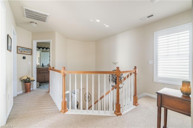 hallway featuring light colored carpet