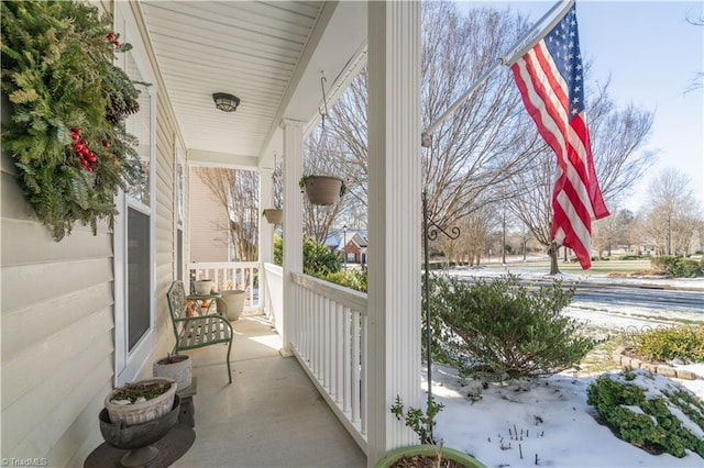 snow covered patio featuring a porch