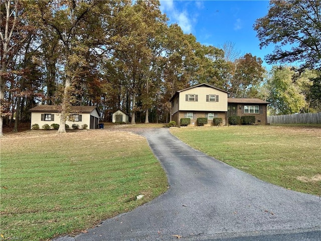 split level home with a front yard and a shed