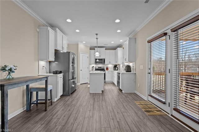 1318 Reading Ct, Burlington, NC 27217 - kitchen with stainless steel appliances, ornamental molding, white cabinetry, a kitchen island, and wood finished floors