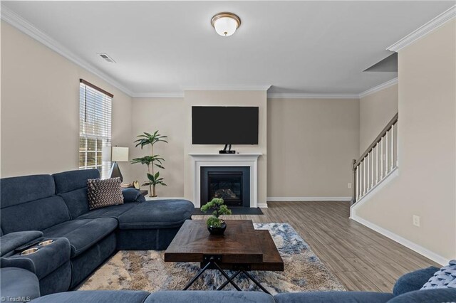 1318 Reading Ct, Burlington, NC 27217 - living room with crown molding, visible vents, a fireplace with flush hearth, wood finished floors, and baseboards