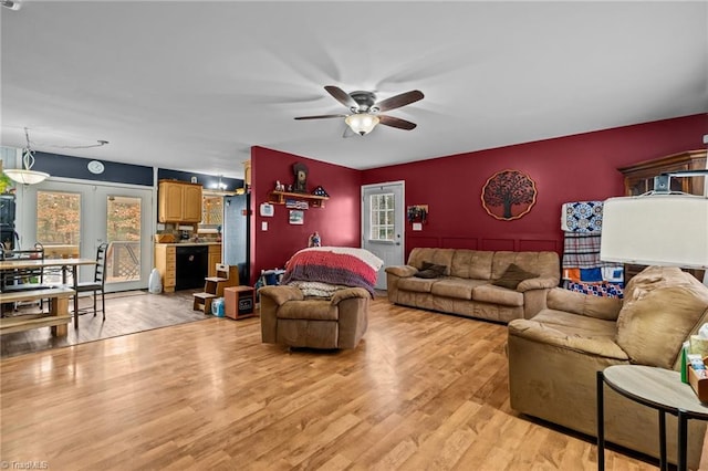 living room featuring french doors, ceiling fan, and light hardwood / wood-style flooring