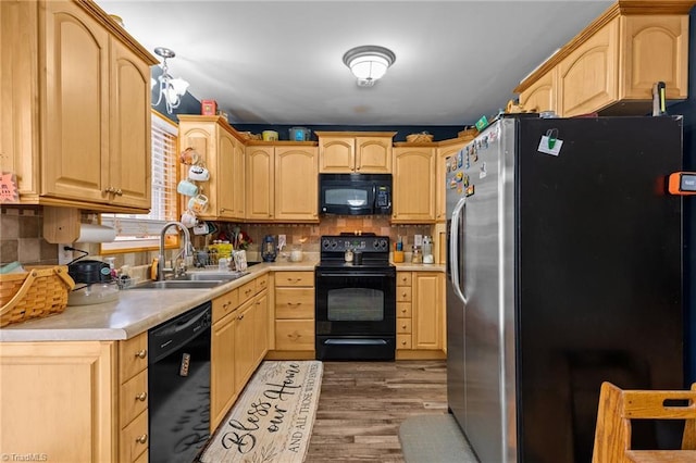 kitchen with sink, light brown cabinetry, and black appliances