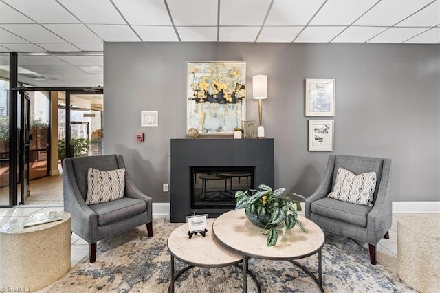 1101 N Elm St Unit 902, Greensboro, NC 27401 - sitting room featuring a drop ceiling, baseboards, and a glass covered fireplace