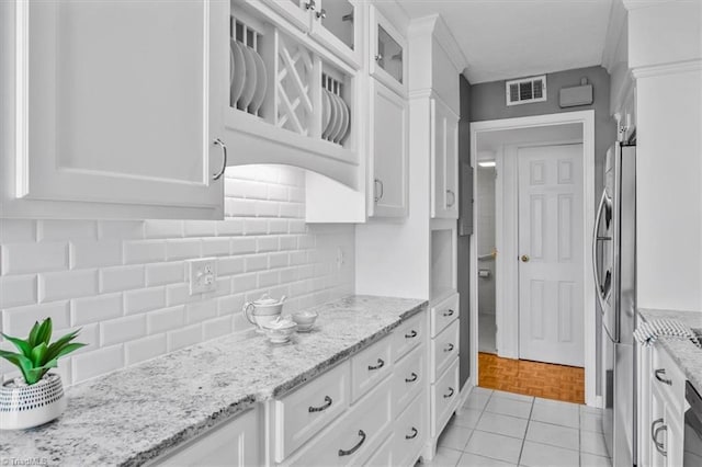 1101 N Elm St Unit 902, Greensboro, NC 27401 - kitchen featuring white cabinetry, stainless steel fridge with ice dispenser, glass insert cabinets, backsplash, and light tile patterned floors