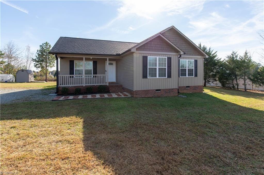 view of front of home with covered porch and a front lawn