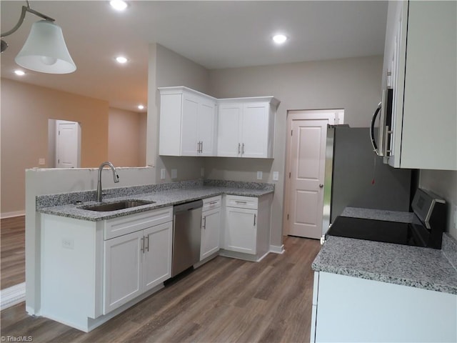 kitchen with sink, wood-type flooring, stainless steel appliances, and white cabinets