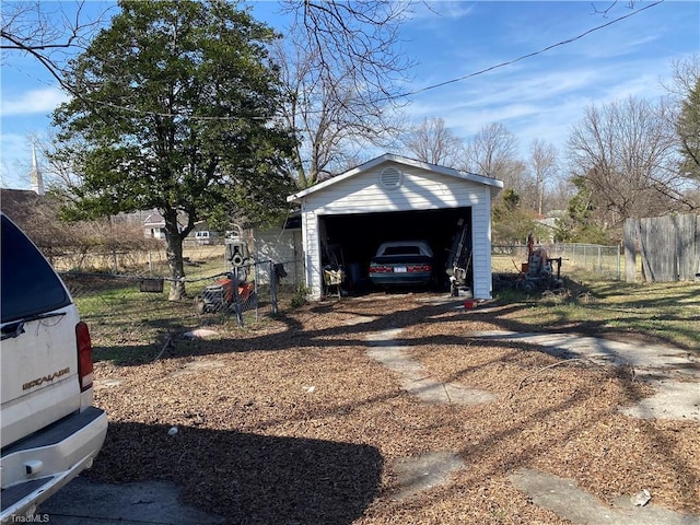 detached garage with fence and driveway