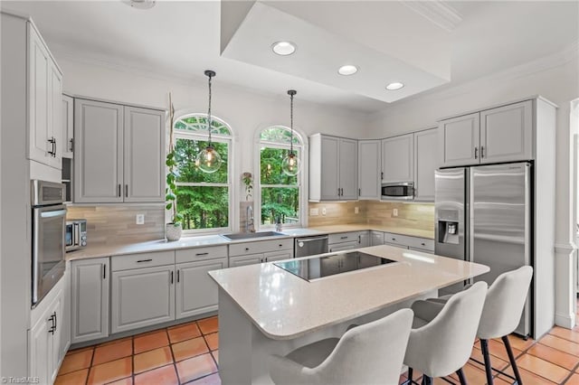 2020 La Dora Dr, High Point, NC 27265 - kitchen featuring appliances with stainless steel finishes, a kitchen breakfast bar, crown molding, a center island, and light tile patterned floors