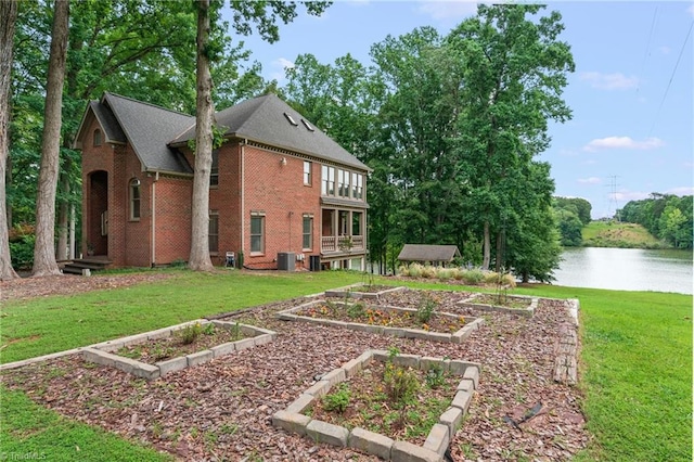 2020 La Dora Dr, High Point, NC 27265 - rear view of house with a vegetable garden, brick siding, a lawn, and a water view