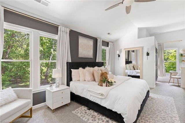 bedroom with multiple windows, vaulted ceiling, baseboards, light colored carpet, and ceiling fan
