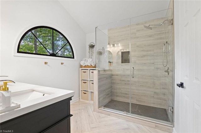 bathroom with vaulted ceiling, vanity, and a shower stall