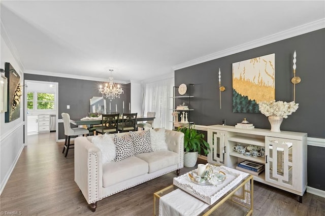 living room featuring a chandelier, ornamental molding, wood finished floors, and baseboards