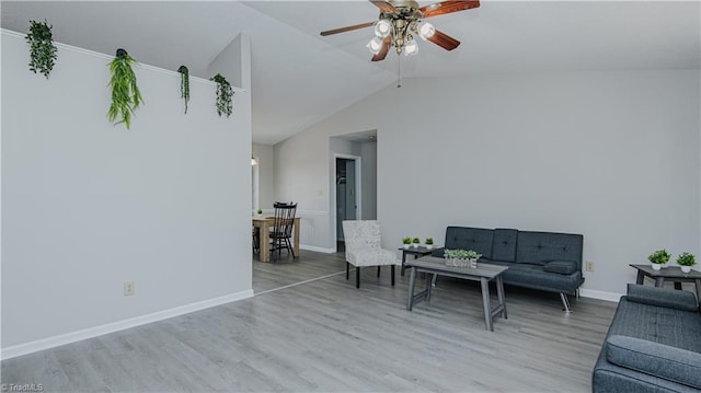 sitting room with ceiling fan, baseboards, wood finished floors, and vaulted ceiling